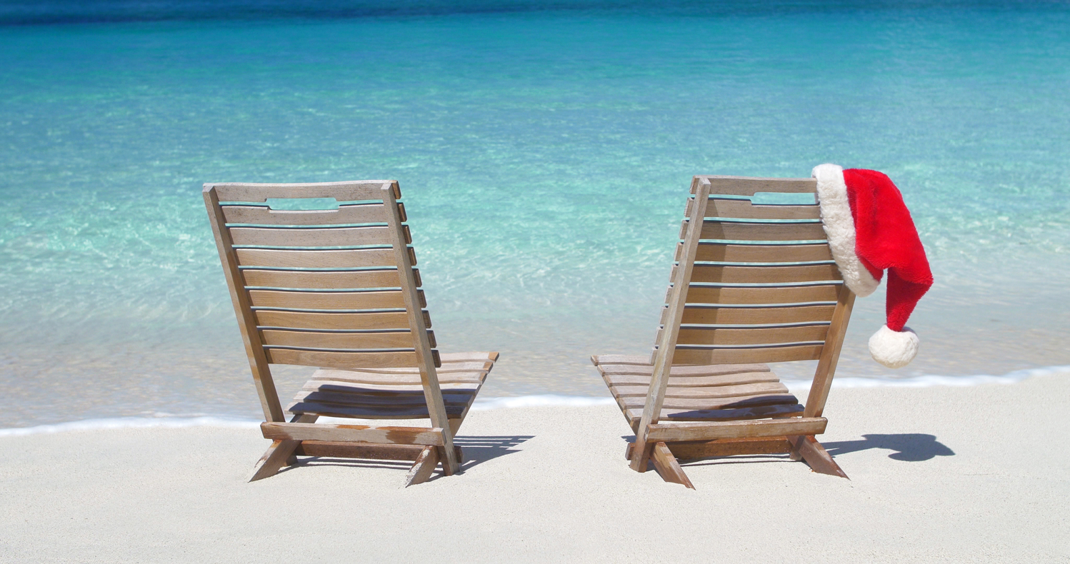 Chapeau de Père Noël sur des chaises de plage sur la plage