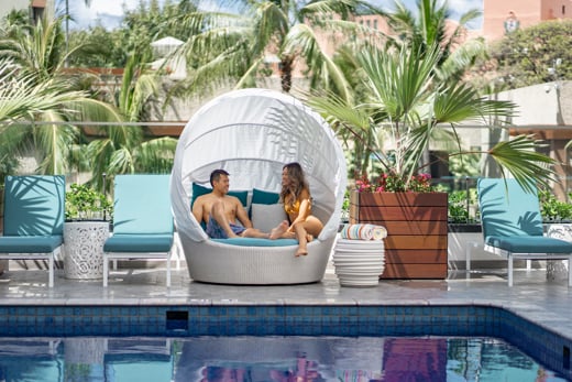 Les clients profitent de la piscine de l’Outrigger Waikiki Beachcomber Hotel.