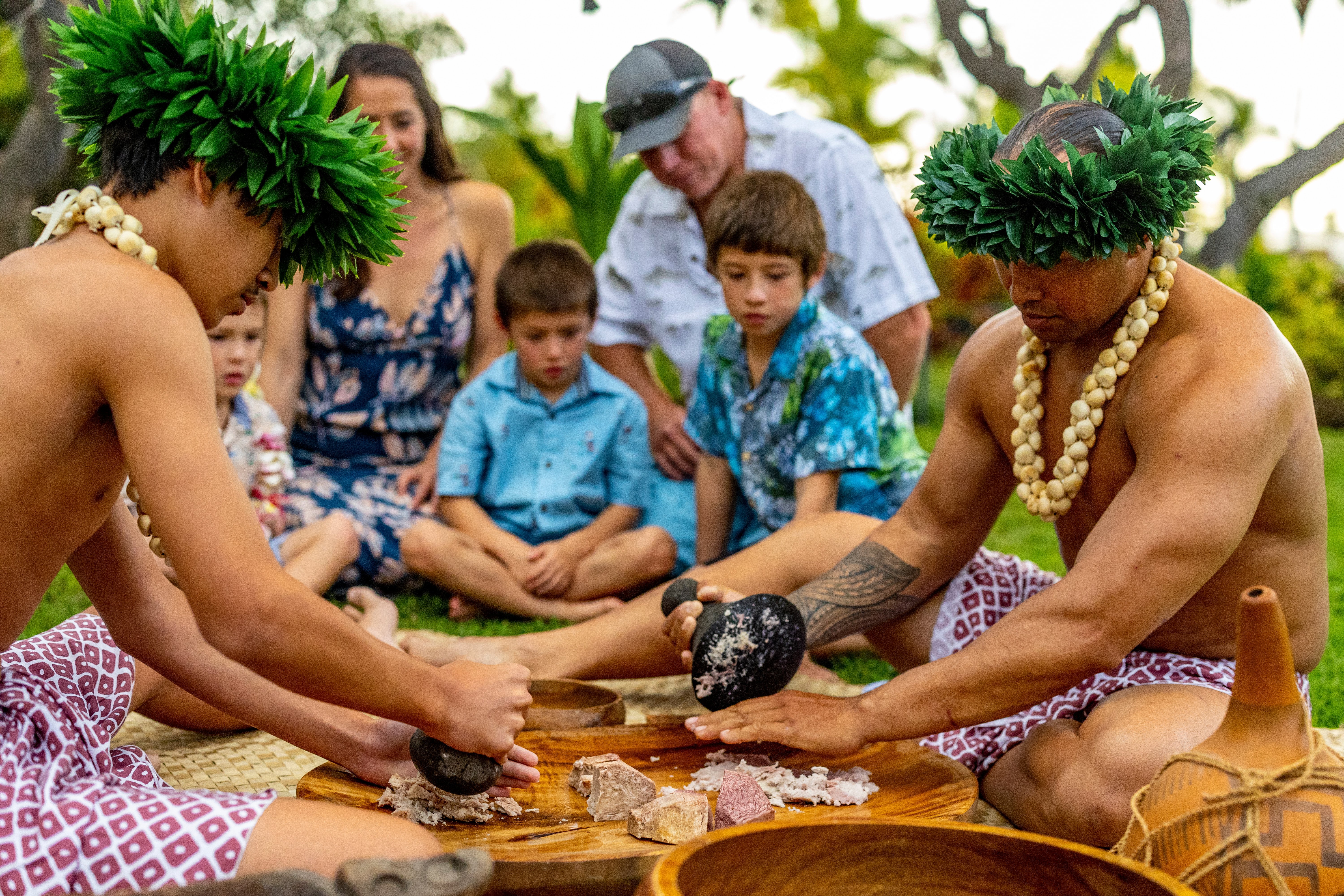 Family participating in cultural activities at Feast & Fire Luau