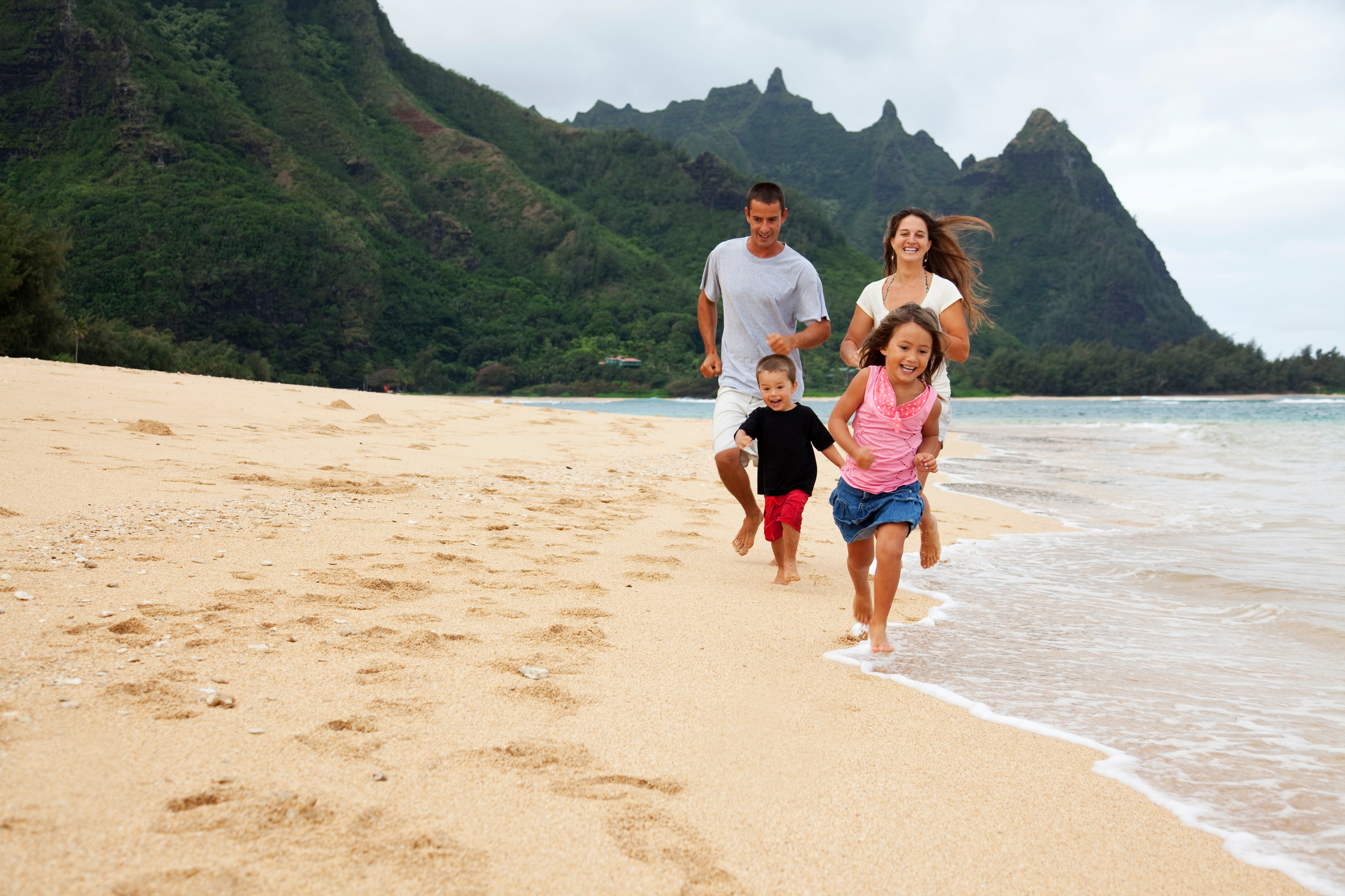 Famille courant sur une plage de Kauai